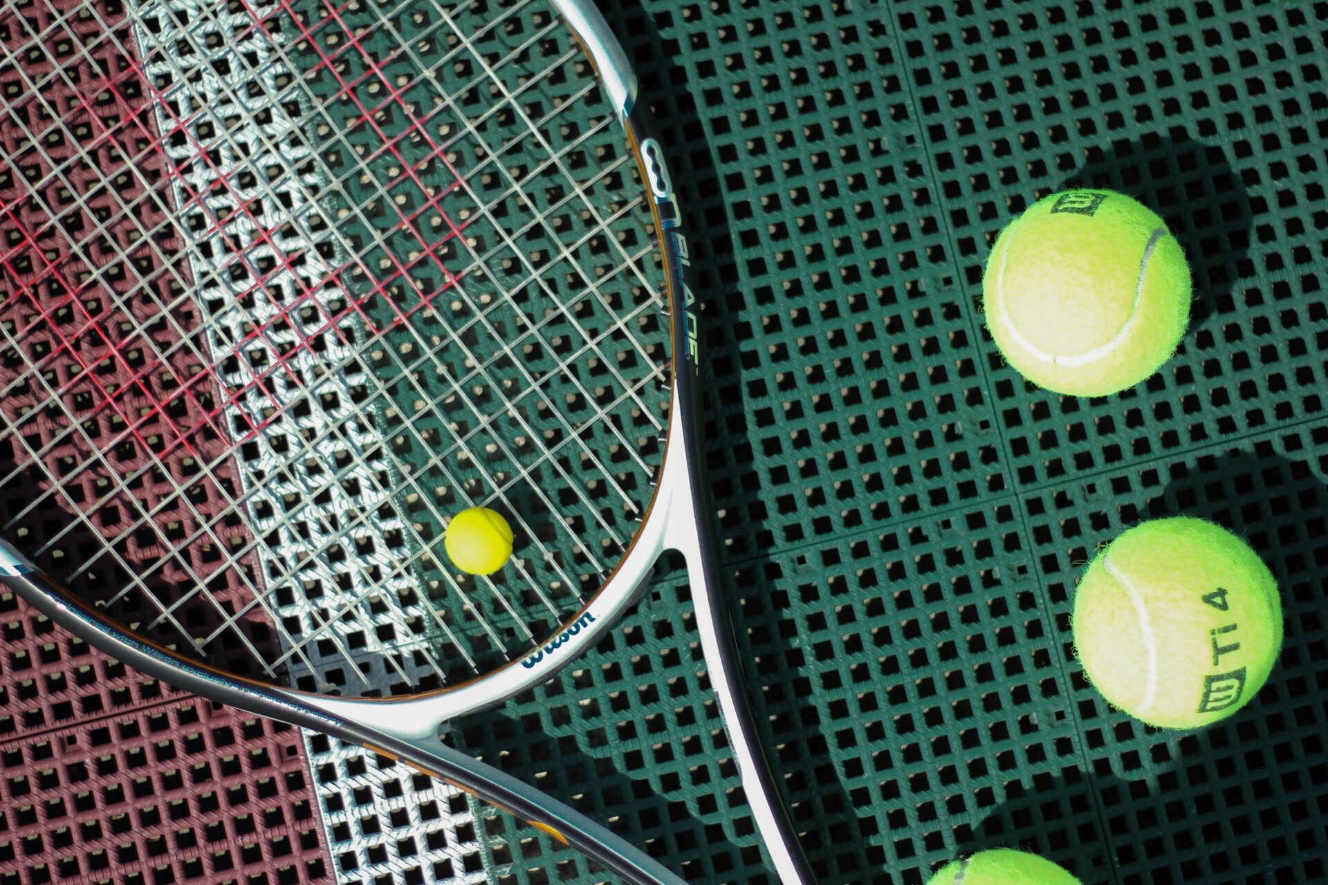 A tennis racket wiith some tennis balls.