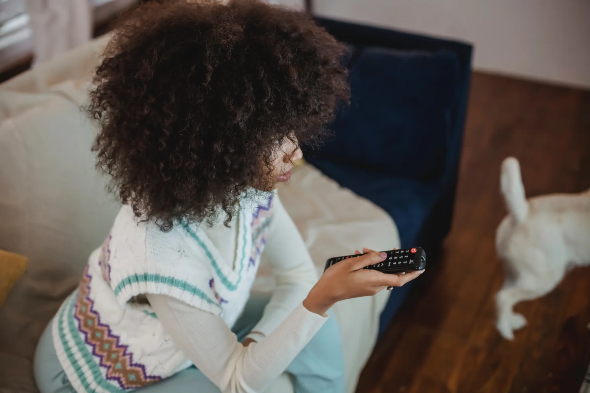 A woman sitting on the couch watching TV and holding a remote control, with reference to the introduction of online freeview.